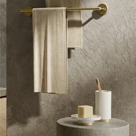 Brass towel rail and bathroom accessories against a stone wall