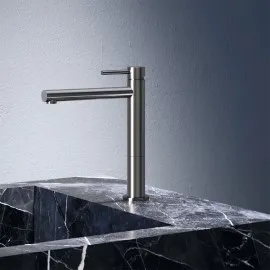 Brushed metal basin mixer above a dark marble basin