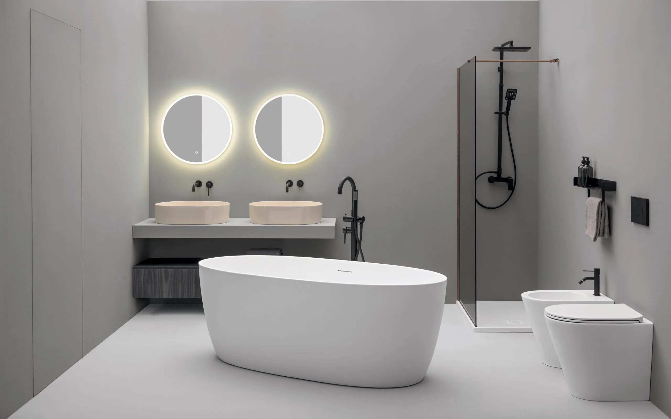 Contemporary bathroom with twin basins, a freestanding bath and dark shower fittings